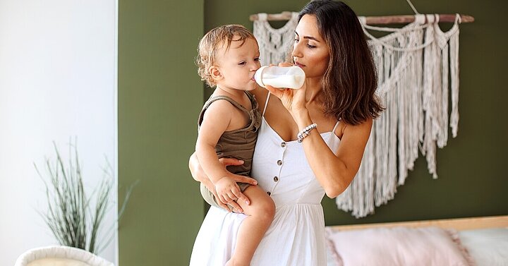 Mum bottle feeding one year old daughter