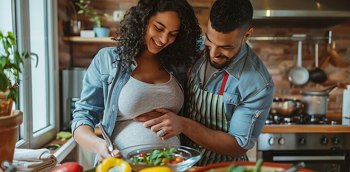 Expecting couple preparing meal together