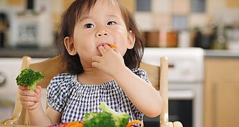 Little girl eating vegetables