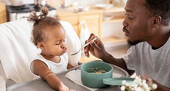 Dad feeding daughter