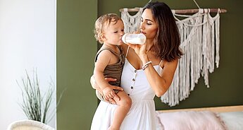 Mum bottle feeding one year old daughter